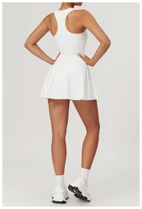 Back view of a white racerback athletic dress with a pleated A-line hem for tennis