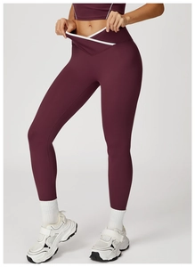 Detail van yogabroek met een gekruiste taille en contrasterende witte biezen