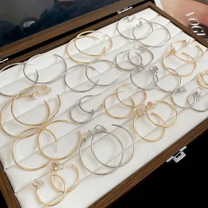 Minimalist gold and silver round hoop earring set with various sizes in a jewelry box