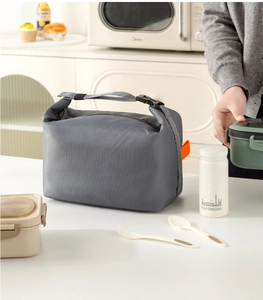Detail of waterproof grey insulated lunch bag with roll-top buckle and orange webbing