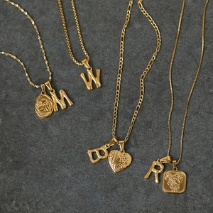 18K gold plated bamboo style 26 English letter pendants and necklaces on stone background