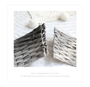 Macro shot of hand-woven grey and beige Christmas tree collar on a plush white base