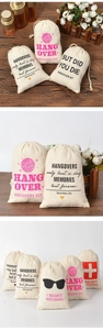 Detail of linen drawstring hangover kit bags with various printed designs on wood background