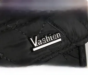 Detail of black quilted windproof hat with Vashion metal logo and embroidery