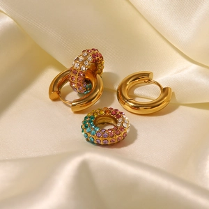 Detail of 18k gold-plated hoops and rainbow crystal earrings on golden silk fabric