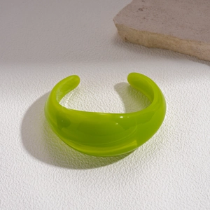 Detail of lime green acrylic cuff bracelet with high gloss finish and minimalist style