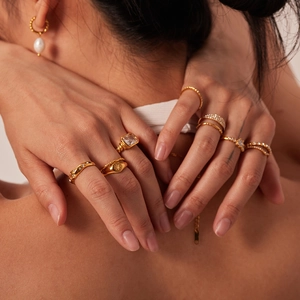 French style 18K gold titanium steel rings and pearl earrings set worn by a female model