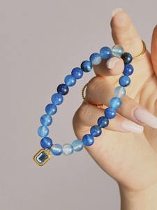 Detail of blue agate beaded bracelet with a gold rectangular gemstone pendant