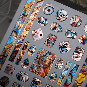 Adesivi per unghie metallici con motivi marmorei colorati e trame di gemme geometriche
