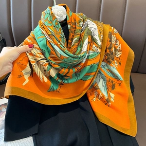 Floral print silk scarf with orange border and camellia flower on black garment
