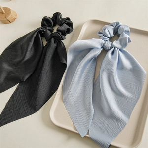 Detail of light blue and black nylon hair scrunchies with streamers and pleated texture