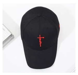 Detailansicht der roten 'faith' Kreuzstickerei auf einer klassischen schwarzen Baseballkappe.