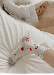 Detail of breathable mesh cotton socks featuring cute apple patterns and grey heel accents