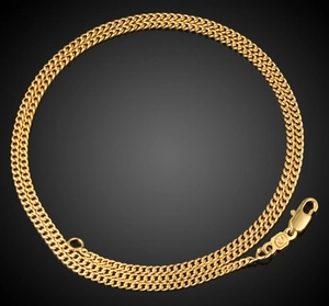 Detail of 18K gold-plated Cuban chain necklace with a lobster clasp on black background