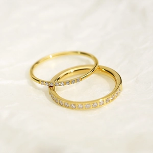 Close-up of two stacked gold-plated stainless steel rings with sparkling cubic zirconia