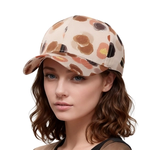 Detailed view of floral abstract print on a beige baseball cap worn by a model