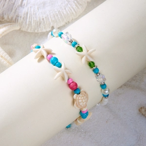 Summer ocean style beaded bracelets with starfish and turtle charms on a beach decor base