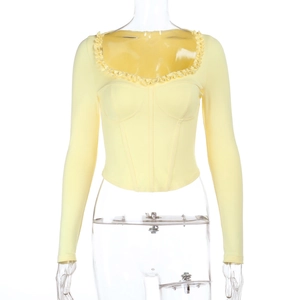 Detail of light yellow long sleeve top with ruffle heart neckline and ribbed texture