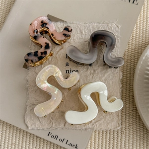 Set of four S-shaped acetate hair claws in leopard, gray, pearl, and ivory finishes