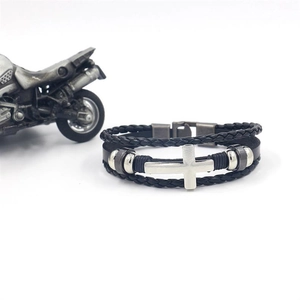 Close-up of multilayer black leather men's bracelet with silver cross and bead details