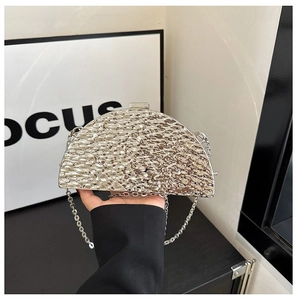 Detailed view of silver metallic dinner clutch with hammered texture and delicate chain