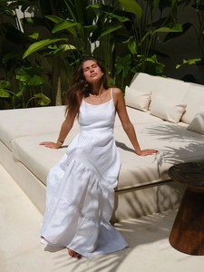 Détail de robe longue blanche à volants et dos nu avec fines bretelles style vacances