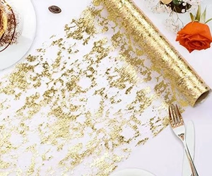 Detail of elegant gold foil mesh table runner with metallic pattern for party decor