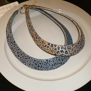 Detail of leopard print choker set with adjustable gold lobster clasp on white plate