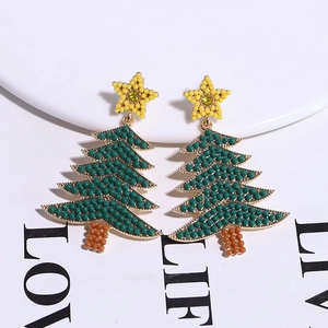 Close-up of Christmas tree earrings with green rhinestones, yellow stars and pearl beads