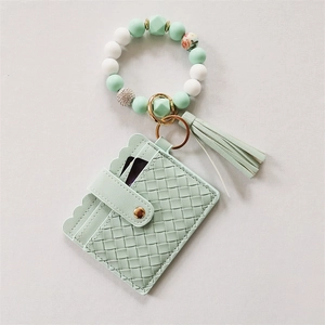 Detail of mint green silicone beaded bracelet with tassel keychain and woven card holder