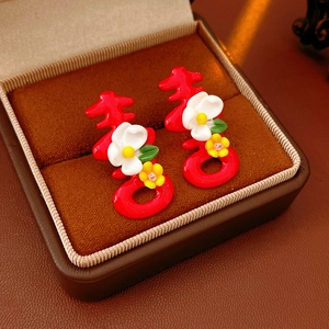 Close-up of red Double Happiness earrings with floral detail in a jewelry gift box