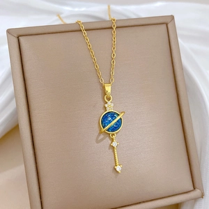 Detail of star-shaped gold necklace with blue planet pendant on beige jewelry box