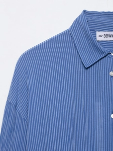 Détail du col de chemise à rayures bleues et blanches avec coutures et texture coton