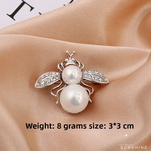 Detail of bee brooch with pearls and zircons on champagne satin, 3x3.5cm and 8g weight