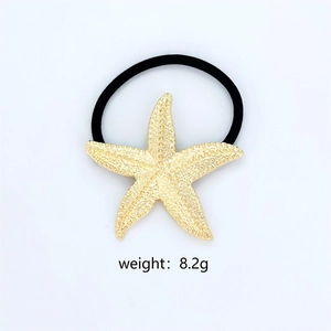 Detail of a golden starfish hair tie on white background weighing 8.2g for beach style