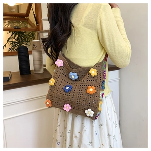 Detail shot of a brown crochet shoulder bag with colorful 3D knitted flowers