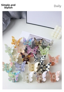 Detailed top view of butterfly hair claws with various marble and checkered patterns