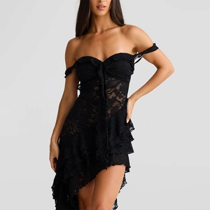 Detail of black lace off-shoulder dress with ruffled edges and asymmetrical hemline