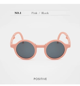 Front view of pink foldable children's sunglasses with dark round lenses and matte finish