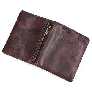 Macro shot of dark brown genuine leather wallet texture with center metal zipper detail