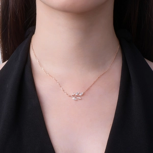 Detailed view of an 18K rose gold leaf necklace with marquise-cut marquise stones