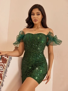 Détail de la robe courte verte à paillettes avec manches en tulle et coupe moulante
