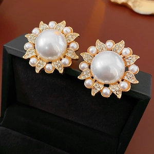 Macro shot of luxury flower earrings with pearls and crystals on a velvet base