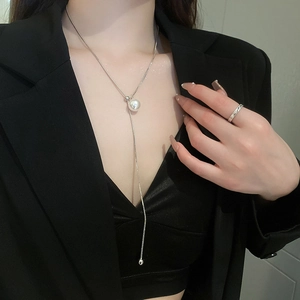 Detail of silver snake chain necklace featuring a large pearl pendant and subtle crystal drop