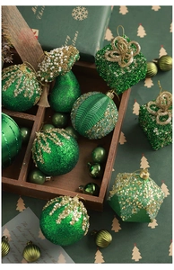 Green and gold flocked Christmas ornaments with glitter details on vintage wooden tray