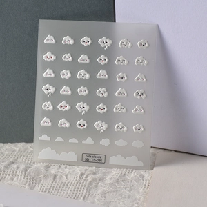 Macro detail of 5D embossed nail stickers featuring cute white clouds with facial expressions