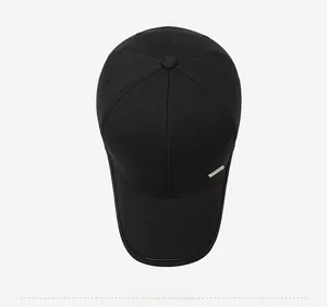 Top-down view of black six-panel baseball cap with metal accent and curved brim