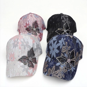 Close-up of lace baseball caps with rhinestone butterflies in multiple colors