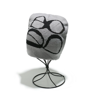 Macro view of grey knit beanie featuring black gothic eye jacquard pattern detail