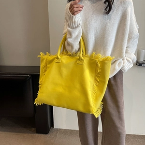 Minimalist yellow canvas tote bag with fringe edges and double handles for women